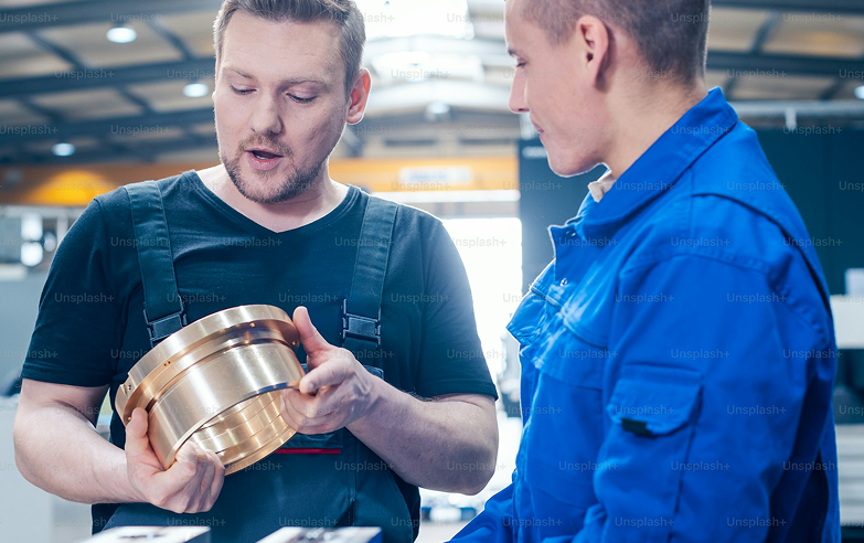 Profissionais da Amaral analisando componente de alumínio